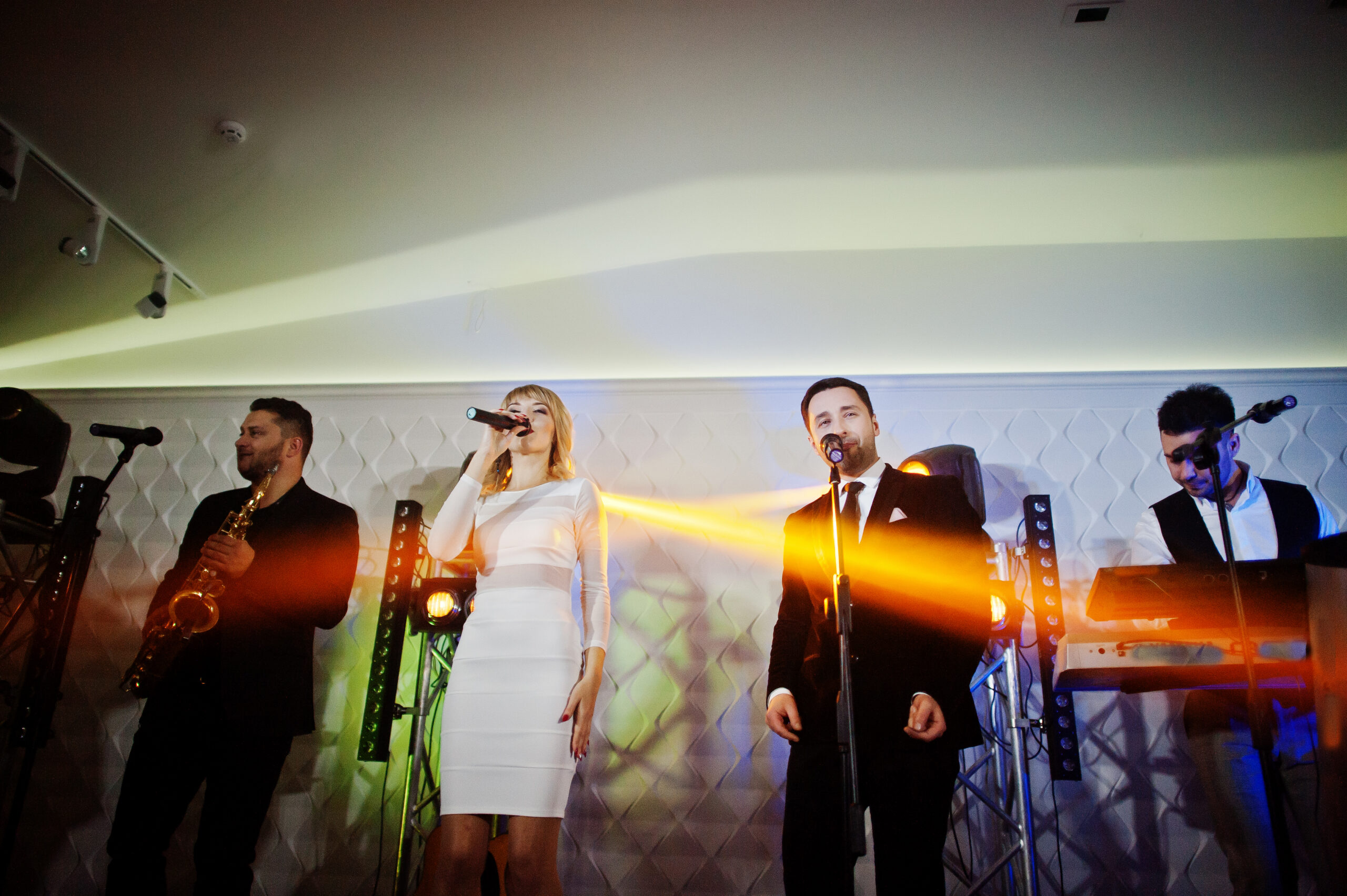 Musicial music live band performing on a stage with different lights.